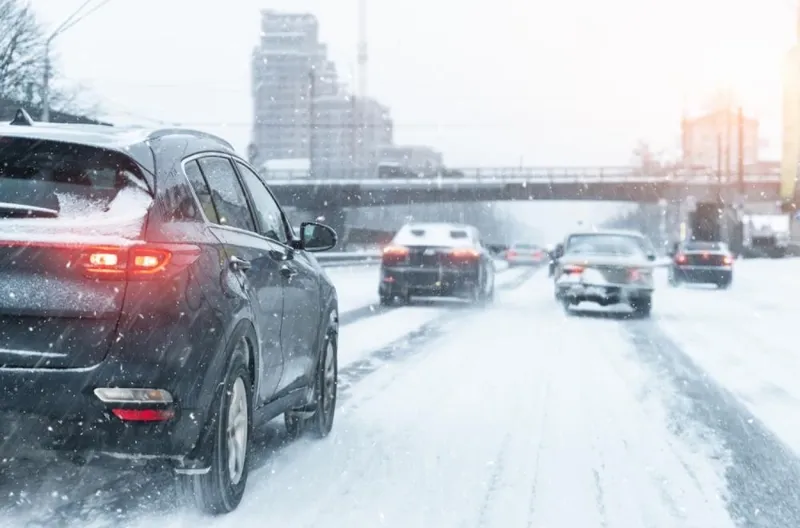 Cars driving on a snow-covered city road