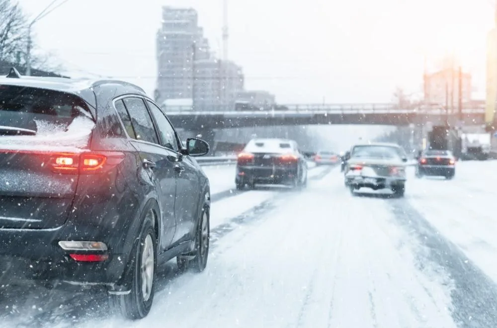 Automobili u vožnji po zavejanom gradskom putu